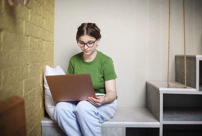 Girl using laptop while sitting at home