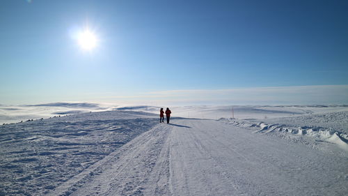 People on snow covered mountain against sky