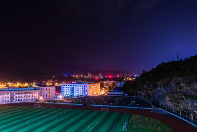 High angle view of illuminated city buildings at night