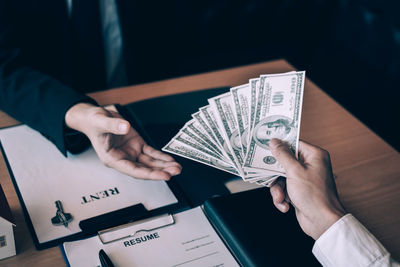 High angle view of man holding paper on table