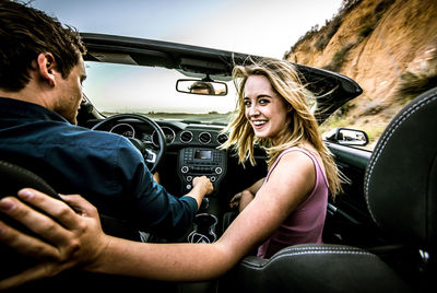 Portrait of a smiling young woman sitting in car