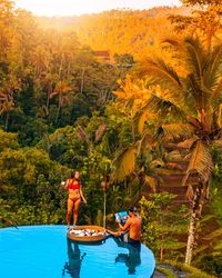 Men standing by palm trees and plants