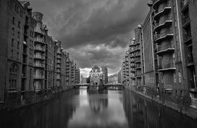 Buildings in city against cloudy sky