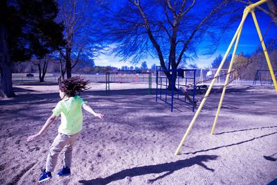 Boy playing soccer against sky