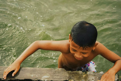 High angle view of shirtless boy in water