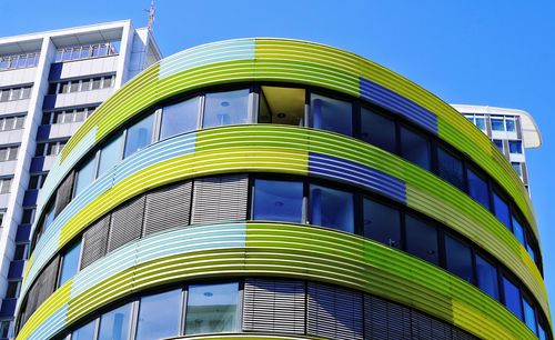 Low angle view of modern building against clear blue sky