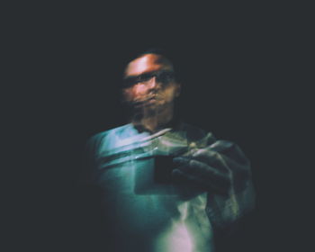 Close-up of man against black background