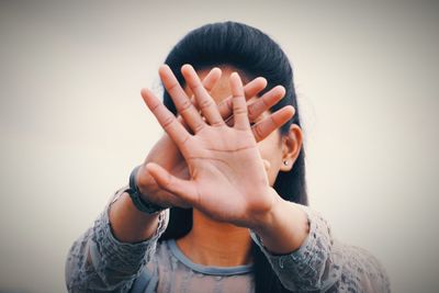 Portrait of person covering face with hands