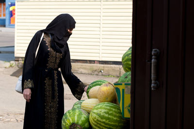 Rear view of woman standing against wall