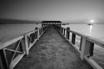 Empty pier over sea against sky