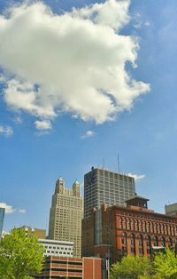 Low angle view of buildings against cloudy sky