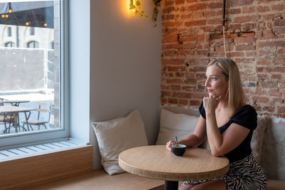 Young woman using phone while sitting at home