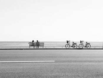 Bicycles on beach against clear sky