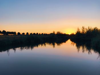 Scenic view of lake against sky during sunset