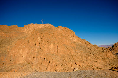 Low angle view of rock formations against clear blue sky