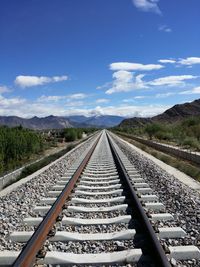 Railway tracks on landscape against sky