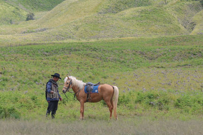 Rear view of man and woman with dog on farm