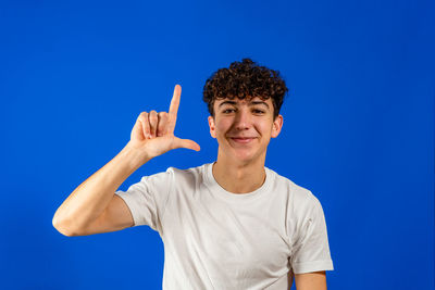 Portrait of smiling man standing against blue background