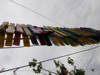 Low angle view of clothespins against sky