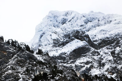 Low angle view of snowcapped mountains against clear sky