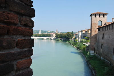 Arch bridge over river against buildings