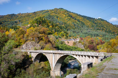 Arch bridge over mountains against sky