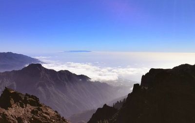 Scenic view of mountain range against blue sky