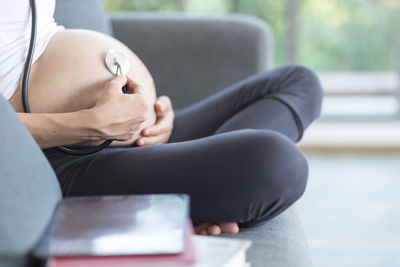Midsection of woman sitting on seat