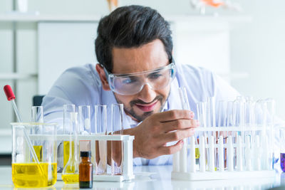 Side view of scientist examining chemical in laboratory