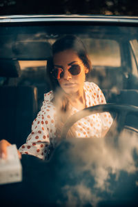 Woman wearing sunglasses sitting in car