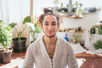 Portrait of smiling young woman sitting at home