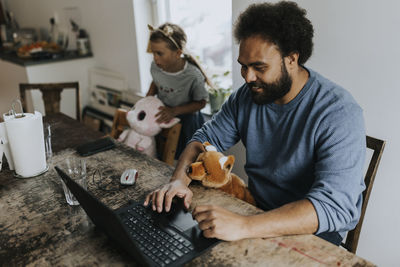 Man working from home and taking care of child