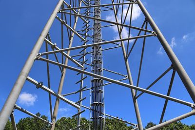 Low angle view of communications tower against blue sky
