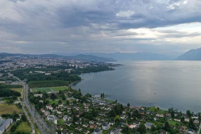 High angle view of townscape by sea against sky