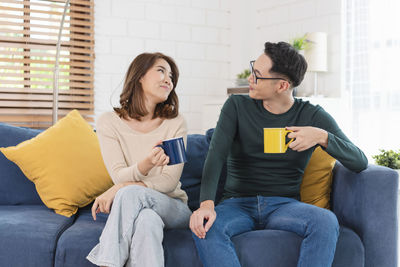 Young couple sitting on sofa at home