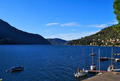 Boats in sea against blue sky