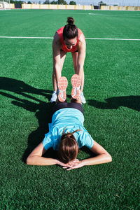 Two women help each other practice their stretching