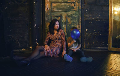 Mother with daughter sitting on floor at home