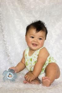 Cute baby boy sitting on fur sheet