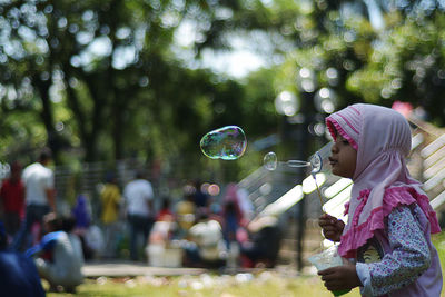 Girl blowing bubbles outdoors