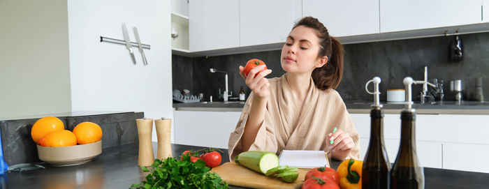 Portrait of young woman using mobile phone at home