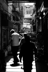 Rear view of people walking on street at night