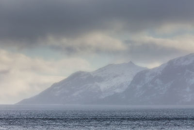 Scenic view of sea and mountains against sky