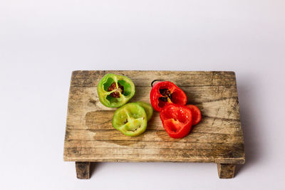 Close-up of fruits and vegetables on cutting board against white background
