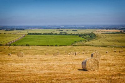 Hay bales on field against sky