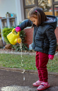 Rear view of girl holding umbrella