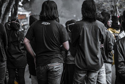 Rear view of people walking on street in city