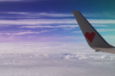 Airplane flying over clouds in sky