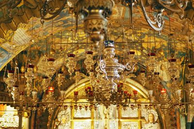 Low angle view of illuminated chandelier hanging on ceiling