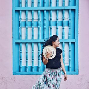 Young woman standing against wall